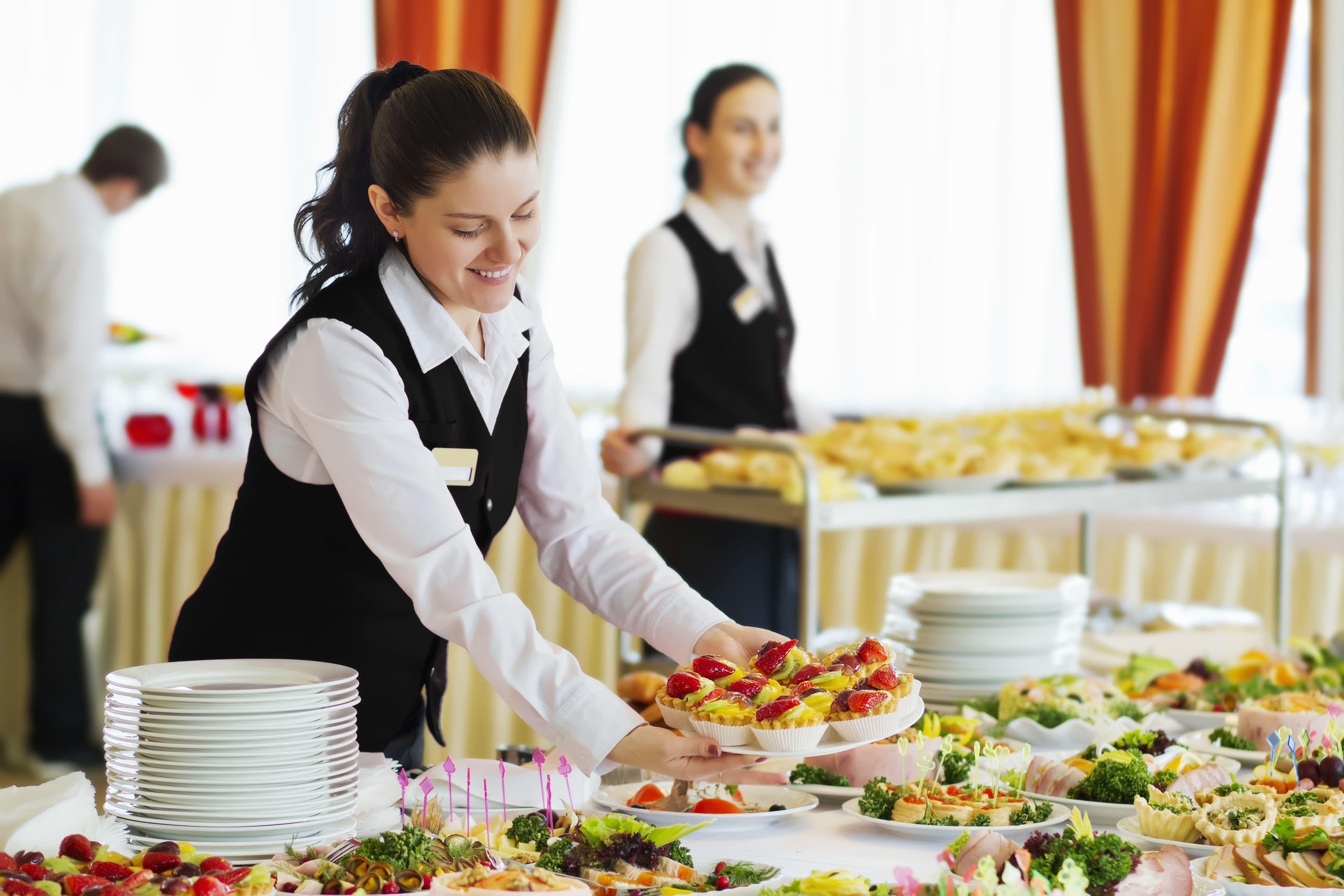 Catering staff laying out a banquet buffet